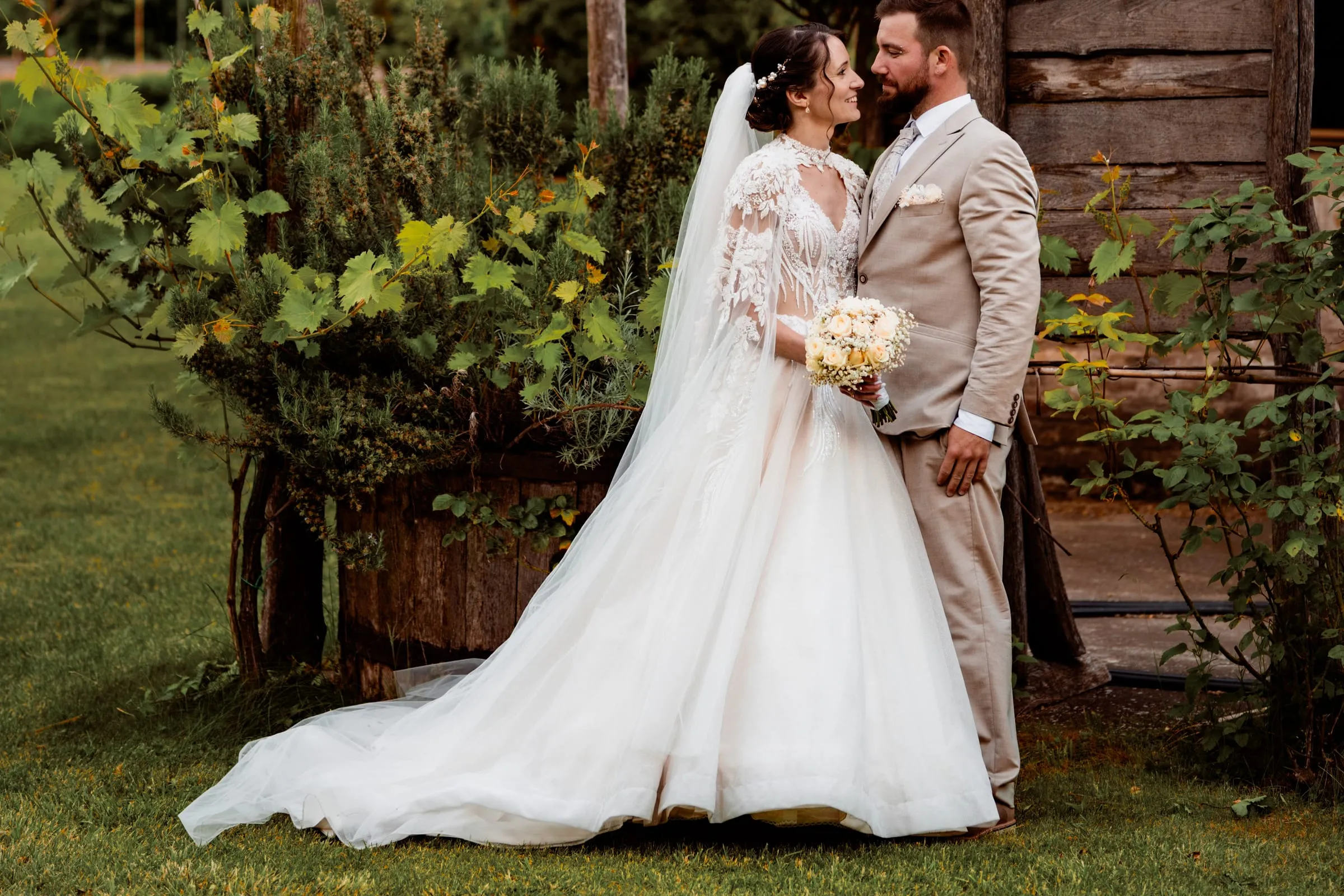 Newlyweds by the wooden barn in the park