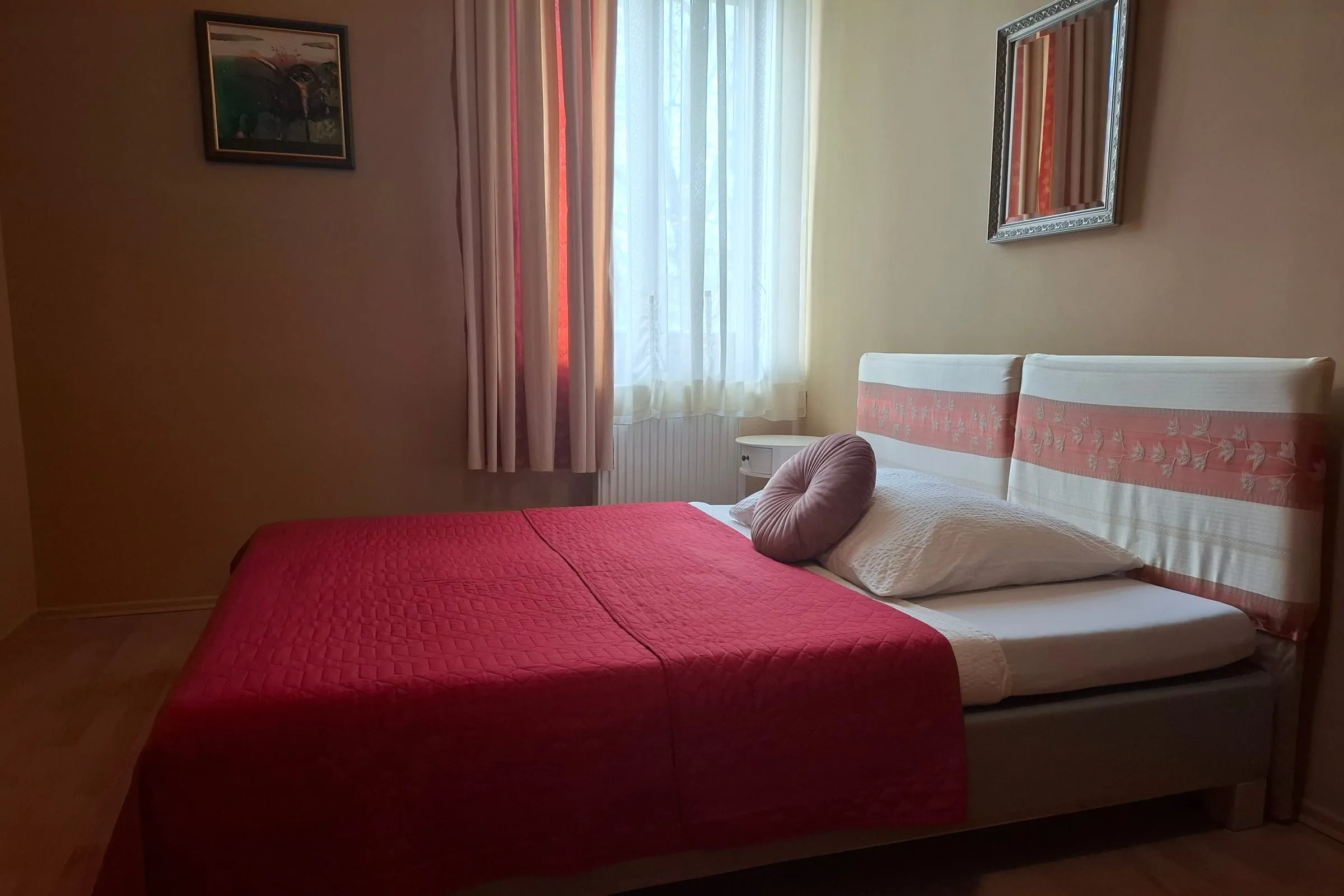 Room with a double bed and murals on the walls