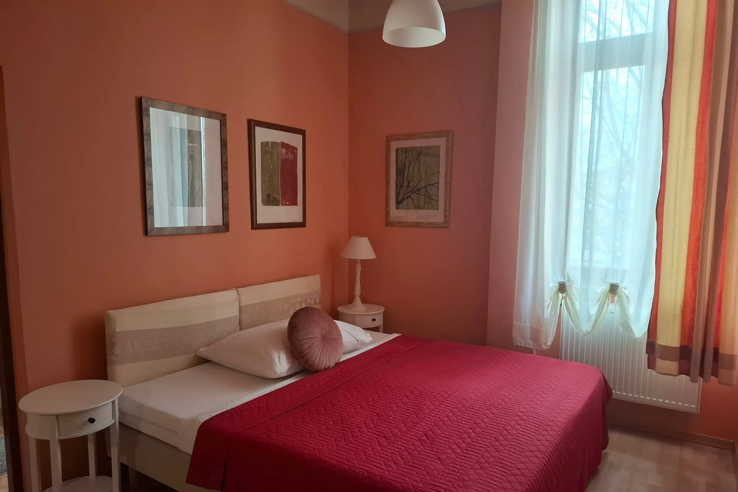 Room with a double bed and a terracotta wall