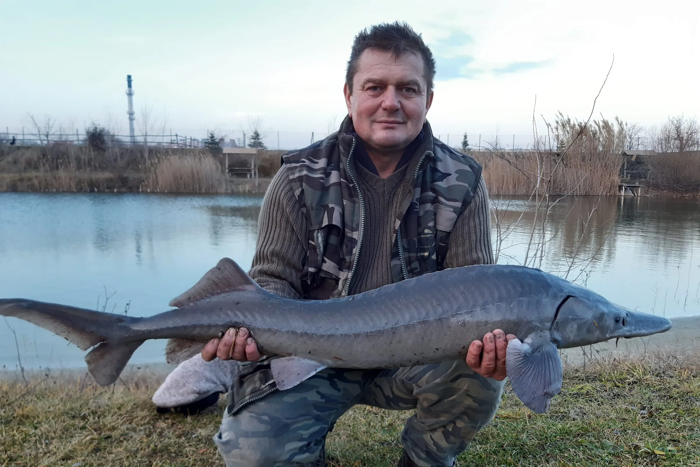 Angler with a sturgeon caught at the lake