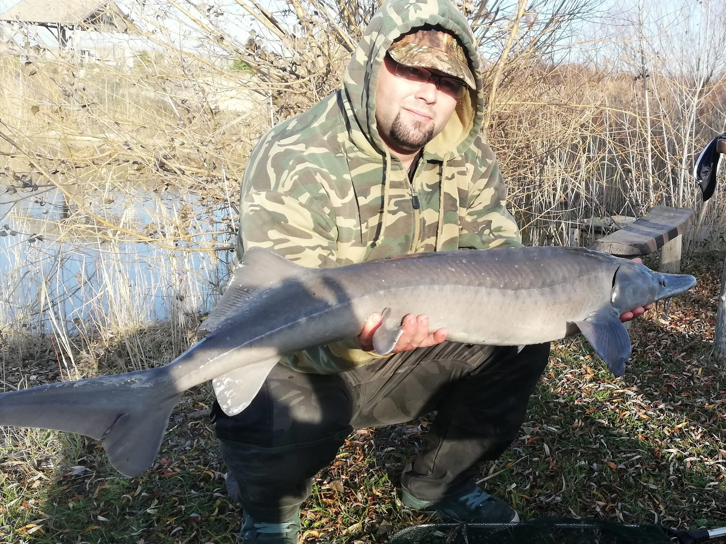 Angler with his catch on the lake shore
