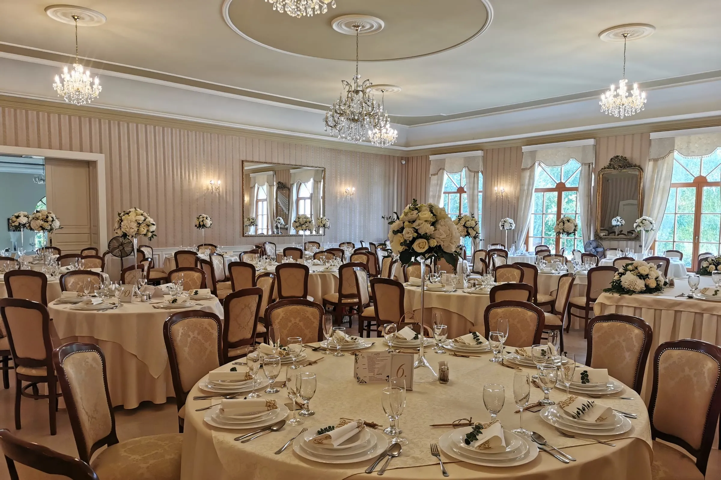 The manor hall with chandeliers, laid for a banquet