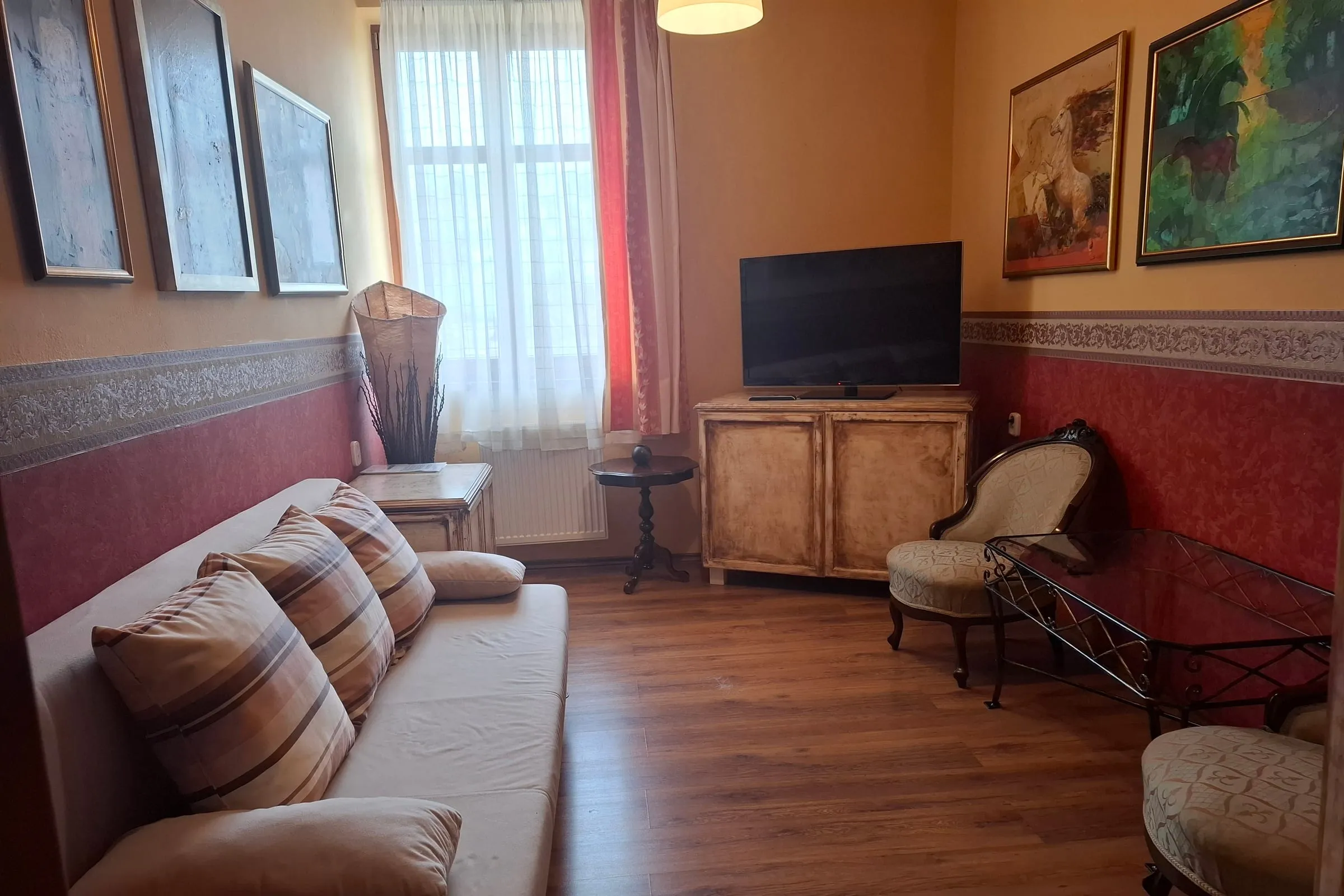 Living area of a suite with a sofa and television